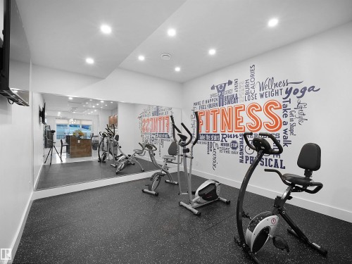 Dedicated fitness space featuring resilient flooring and a mirrored wall - 4809 Woolsey Lane Nw, Edmonton, AB 