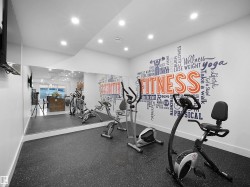 Dedicated fitness space featuring resilient flooring and a mirrored wall - 