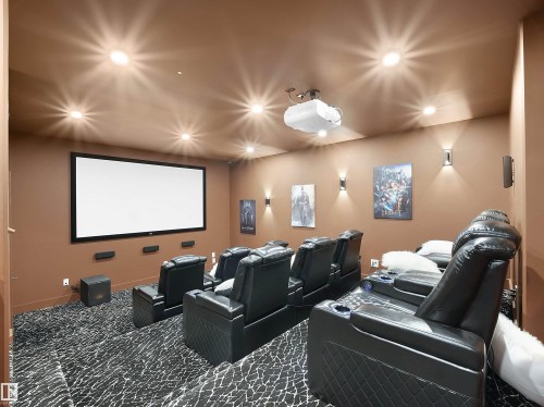 Home Theater featuring a projection screen, tiered black leather seating for multiple viewers, recessed ceiling lighting with integrated fixtures, warm neutral wall finishes with framed artwork, and patterned carpet flooring - 4809 Woolsey Lane Nw, Edmonton, AB 