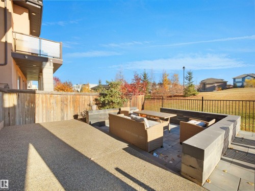 Expansive patio featuring a gravel-finish concrete surface and a paver stone seating area with built-in stone benches - 4809 Woolsey Lane Nw, Edmonton, AB 