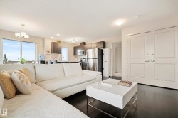 Expansive windows, dark wood-finish flooring, recessed lighting, double-panel bifold doors, and a contemporary kitchen with stainless steel appliances - 
