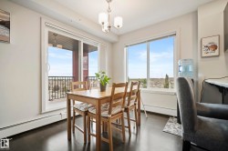 Dark wood-finish flooring, sliding glass door with balcony access, large window, and a ceiling-mounted light fixture - 