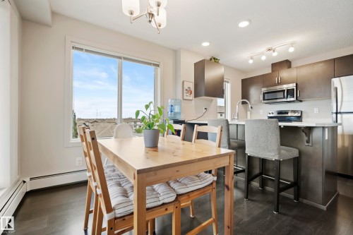 Kitchen with stainless steel appliances, dark wood-finish flooring, and white countertops - #419 5515 7 Av Sw, Edmonton, AB 