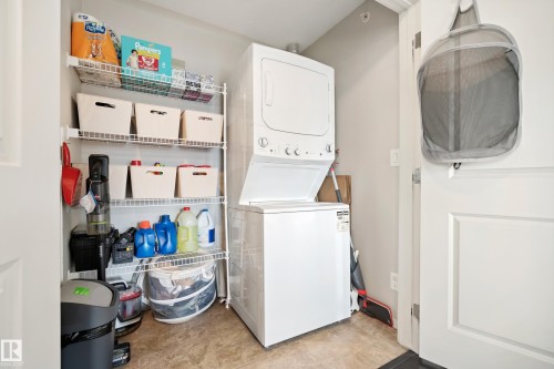 Stackable washer and dryer appliances, wire shelving system, and neutral-toned wall paint - #419 5515 7 Av Sw, Edmonton, AB 