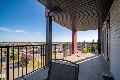 Private balcony featuring a concrete floor, black metal railings, and an exterior wall light fixture - #419 5515 7 Av Sw, Edmonton, AB 