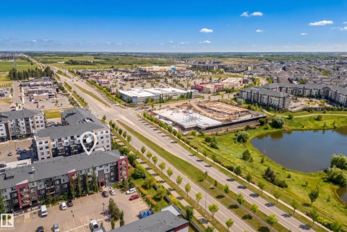 Multi-story apartment building with balconies, adjacent to a paved parking area and landscaped grounds - #419 5515 7 Av Sw, Edmonton, AB 