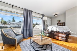 Light wood-finish flooring, entry with dark tile flooring, white paneled entry door with decorative glass, and a contemporary ceiling light fixture - 