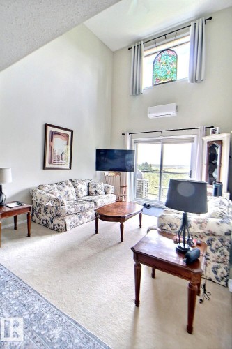 Vaulted ceiling living space with light-toned carpeting - #421 592 Hooke Rd Nw, Edmonton, AB 