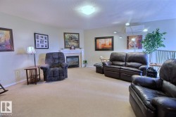 Recessed fireplace with mantel, ceiling-mounted lighting fixture, light-toned carpeting, and white wall finishes - 