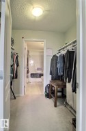Recessed lighting illuminates the space, featuring carpeting and a doorway leading to an additional area - 
