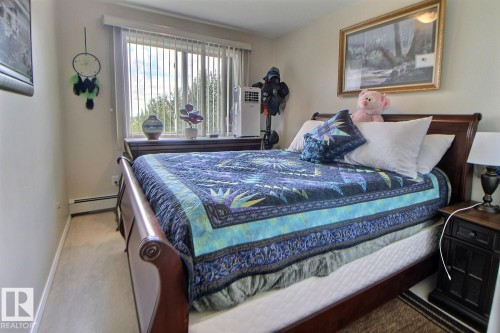 Carpeted flooring with painted walls - #421 592 Hooke Rd Nw, Edmonton, AB 
