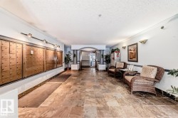 Spacious entry hall featuring tiled flooring, wall-mounted mailboxes, and recessed lighting - 