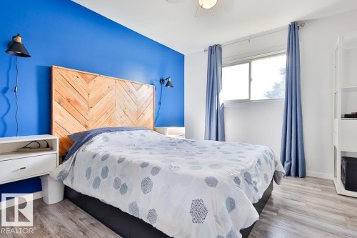 Wood-finish flooring, accent wall, ceiling fan, and window - 13312 123A Street Nw, Edmonton, AB 