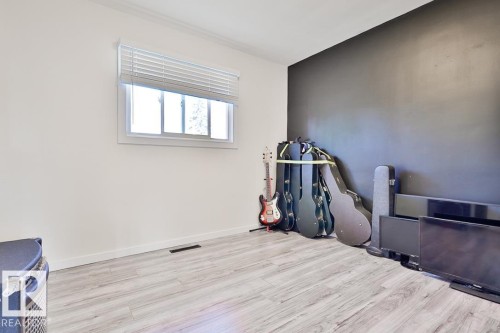 Window with blinds, crown molding, wood-finish flooring, and white walls - 13312 123A Street Nw, Edmonton, AB 