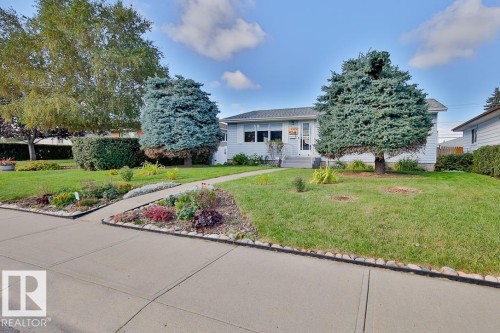 Front exterior with light-colored siding, a gray roof, and a concrete walk path - 13312 123A Street Nw, Edmonton, AB 