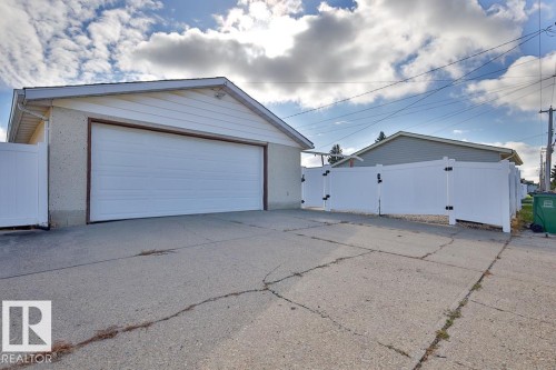 Detached garage featuring a white overhead door and vinyl siding - 13312 123A Street Nw, Edmonton, AB 