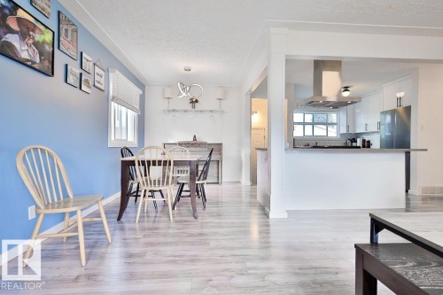Wood-finish flooring throughout, white trim, recessed lighting, white kitchen cabinetry, and stainless steel appliances - 13312 123A Street Nw, Edmonton, AB 