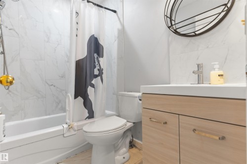 White tile shower surround, integrated bathtub, and a modern vanity with a white countertop - 4824 13 Avenue Nw, Edmonton, AB 