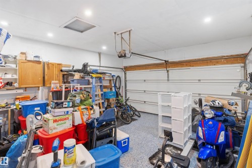 Garage with finished flooring, recessed lighting, wall-mounted cabinetry, and a ceiling access panel - 4824 13 Avenue Nw, Edmonton, AB 