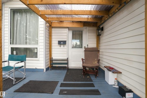 Covered porch with wood frame and translucent roof panels, white siding, and a prominent window - 4824 13 Avenue Nw, Edmonton, AB 