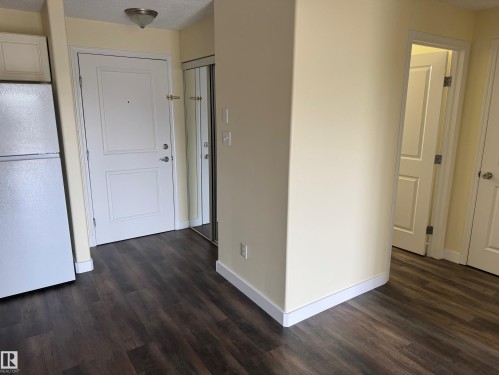 Wood-finish flooring throughout, white interior doors, and pale yellow wall paint - #229 2305 35A Av Nw, Edmonton, AB 