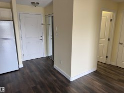 Wood-finish flooring throughout, white interior doors, and pale yellow wall paint - 