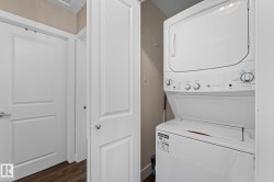 Stacked washer and dryer unit, laminate flooring, and white interior doors - 
