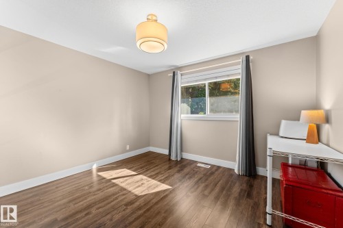 Laminate flooring, neutral wall paint, and a window with blinds and drapes - 6108 102 Avenue Nw, Edmonton, AB 