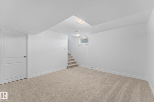Neutral paint colors with ceiling mounted lighting, plush carpeting, and wood-finish flooring, and a visible window - 6108 102 Avenue Nw, Edmonton, AB 