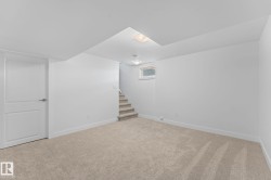 Neutral paint colors with ceiling mounted lighting, plush carpeting, and wood-finish flooring, and a visible window - 