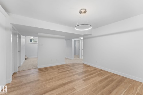 Open-concept dining area with vinyl plank flooring, and white walls - 6108 102 Avenue Nw, Edmonton, AB 