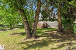 Exterior featuring a wood deck, dark gray siding, and a white entrance door - 