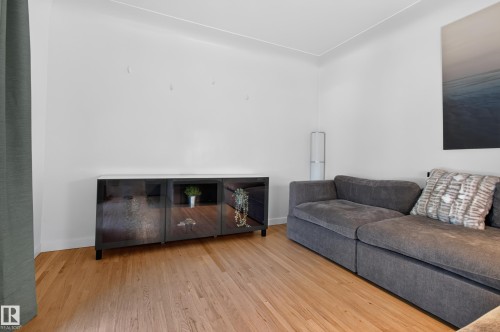 Wood-finish flooring with white baseboards and light-colored walls - 6807 112A Street Nw, Edmonton, AB 