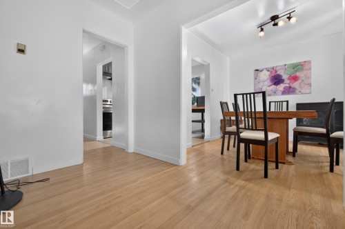 Light wood-finish flooring throughout, white painted walls, and recessed entryways - 6807 112A Street Nw, Edmonton, AB 