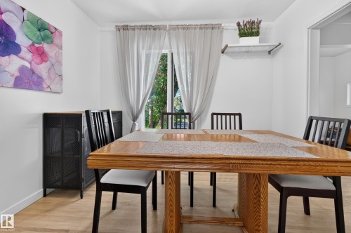 Wood-finish flooring with a multi-pane glass door, white walls, and a built-in floating shelf - 6807 112A Street Nw, Edmonton, AB 