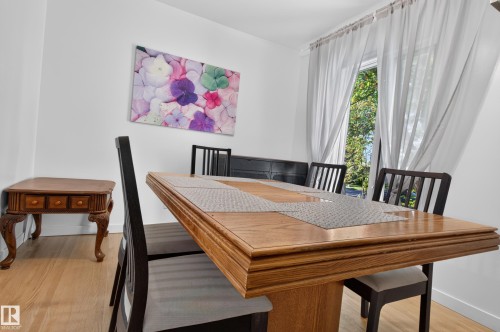 Wood-finish flooring with white walls and a large window - 6807 112A Street Nw, Edmonton, AB 