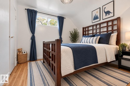 Hardwood-style flooring with a window offering natural light, complemented by white walls and a ceiling-mounted light fixture - 6807 112A Street Nw, Edmonton, AB 