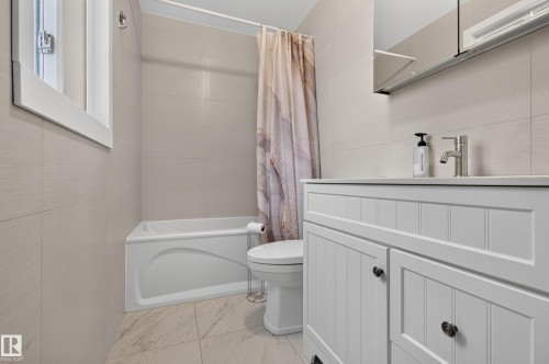 Bathroom featuring a white vanity with beadboard detailing, undermount sink, and brushed nickel faucet - 6807 112A Street Nw, Edmonton, AB 
