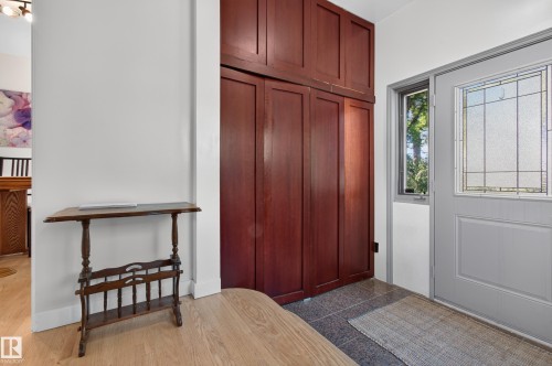 Entryway featuring wood-finish flooring and built-in wood-panel cabinetry - 6807 112A Street Nw, Edmonton, AB 