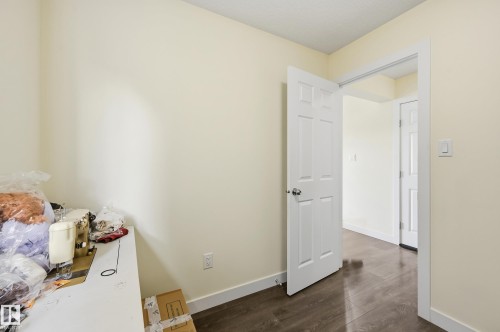 Neutral wall tones, wood-finish flooring, white paneled doors, and white trim throughout - 941 Ebbers Crescent Nw, Edmonton, AB 