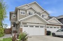 Multi-level facade with light-colored siding, stone accents, and multiple gables - 941 Ebbers Crescent Nw, Edmonton, AB 