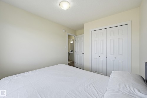 White bi-fold closet doors, flush-mount ceiling light, and light-toned wall paint - 941 Ebbers Crescent Nw, Edmonton, AB 