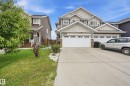 Two-story residence featuring a multi-gable roofline, stone facade accents, and a dual two-car garage - 941 Ebbers Crescent Nw, Edmonton, AB 