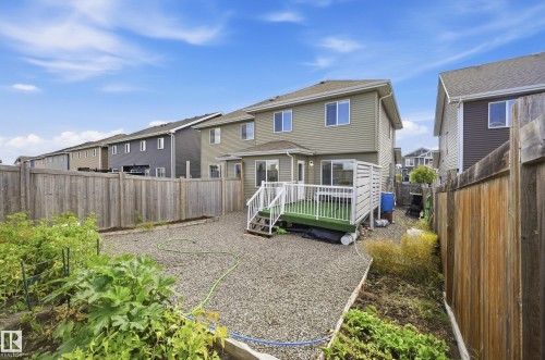 Private fenced backyard featuring a raised deck with white railings, a gravel ground covering, and a garden bed - 941 Ebbers Crescent Nw, Edmonton, AB 