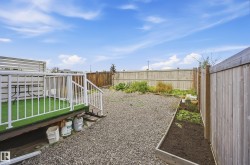 Elevated deck with white railing, artificial turf surface, and slatted privacy screen - 