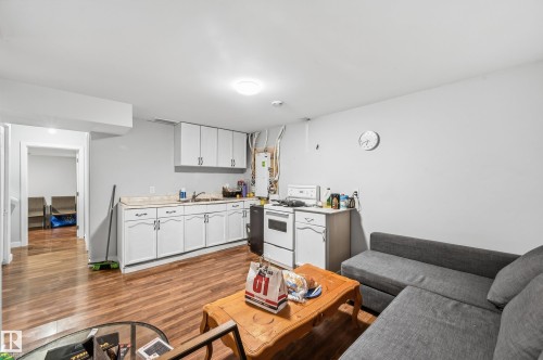 Kitchenette with white cabinetry, wood-finish flooring, and white walls - 941 Ebbers Crescent Nw, Edmonton, AB 