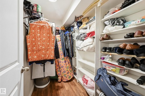 Walk-in closet featuring wood-finish flooring, white shelving, and hanging storage - 941 Ebbers Crescent Nw, Edmonton, AB 