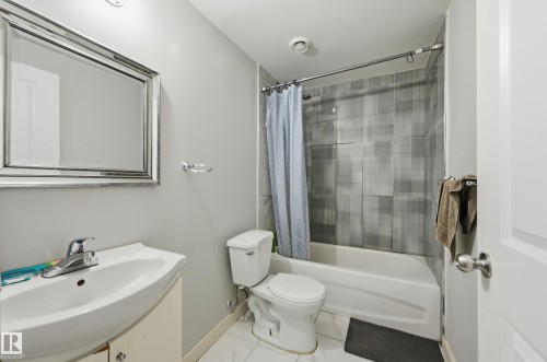 Vanity with integrated sink, chrome faucet, and framed mirror - 941 Ebbers Crescent Nw, Edmonton, AB 