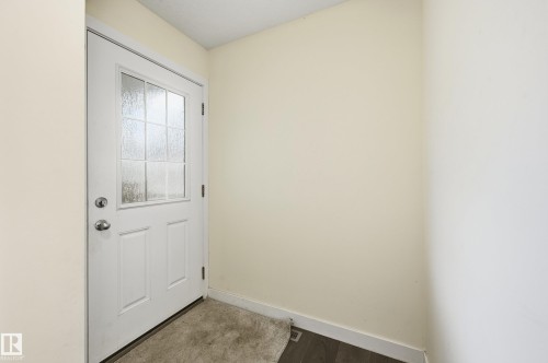White door with decorative glass inserts, chrome hardware, and light-toned walls - 941 Ebbers Crescent Nw, Edmonton, AB 