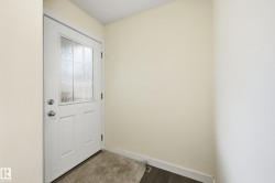 White door with decorative glass inserts, chrome hardware, and light-toned walls - 